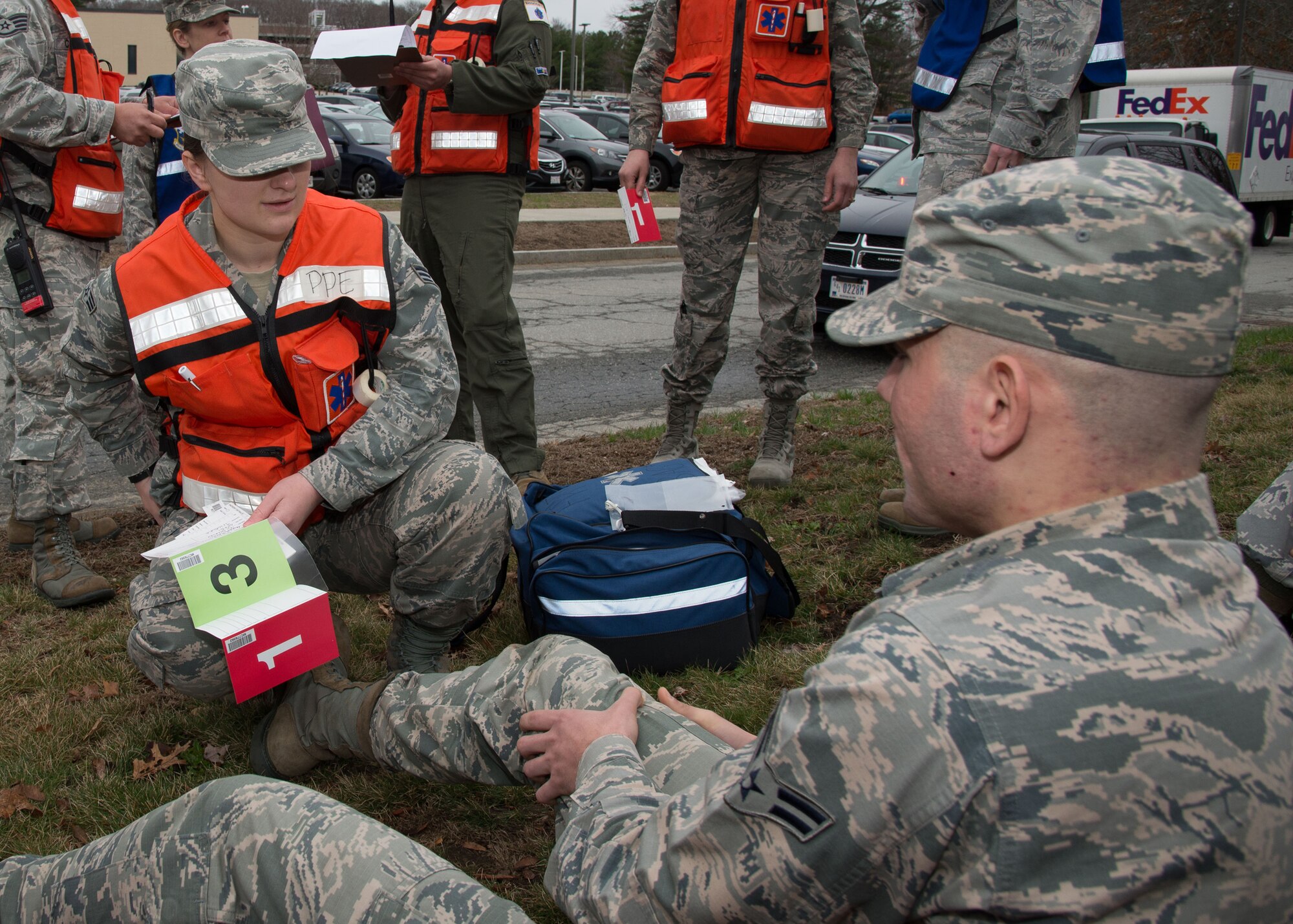 Senior Airman Tatiana Lieback, left, a Field Response Team member assigned to the 66th Medical Squadron, attends to Airman 1st Class Quinton Coker during an active shooter exercise held on base March 16. Members of the Field Response Team set up a temporary triage area outside the Brown Building to treat the victims. Throughout the week, the base performed exercise scenarios to evaluate the installation's readiness and emergency response capabilities. (U.S. Air Force photo by Mark Herlihy) 