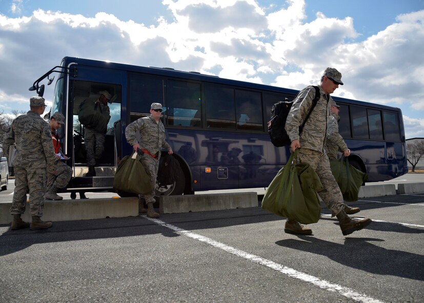U.S. Air Force Airmen step off a bus to go into the mock Personnel Deployment Function at Misawa Air Base, Japan, March 15, 2016. The PDF ensures Airmen have all pre-deployment paperwork required to deploy, are up-to-date on all necessary vaccinations and any other means preventing them from deploying. The PDF kicked-off Beverly Sunrise 16-03, an operational readiness exercise testing Misawa’s mission capabilities. (U.S. Air Force photo by Senior Airman Deana Heitzman)