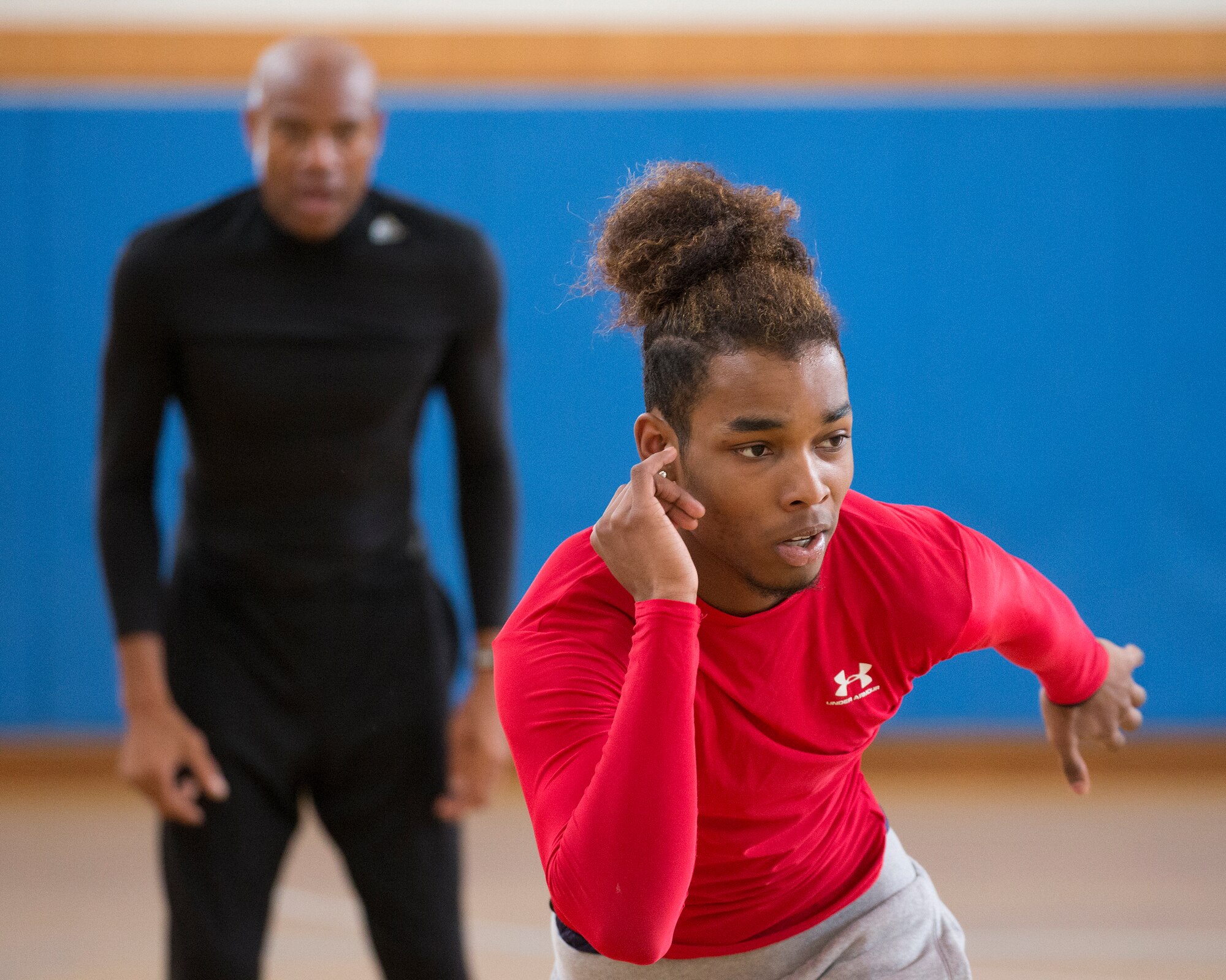 (Right to left) Jarvis Stokes, Yokota High School student, practices body movement to complete a long jump, as Mike Powell, former Olympic participant, watches his form during the World Records Camp at Yokota Air Base, Japan, March 12, 2016. Four track and field gold medalists visited Yokota to coach track and field events. Over 70 students participated in two-day camp. (U.S. Air Force photo by Osakabe Yasuo/Released) 