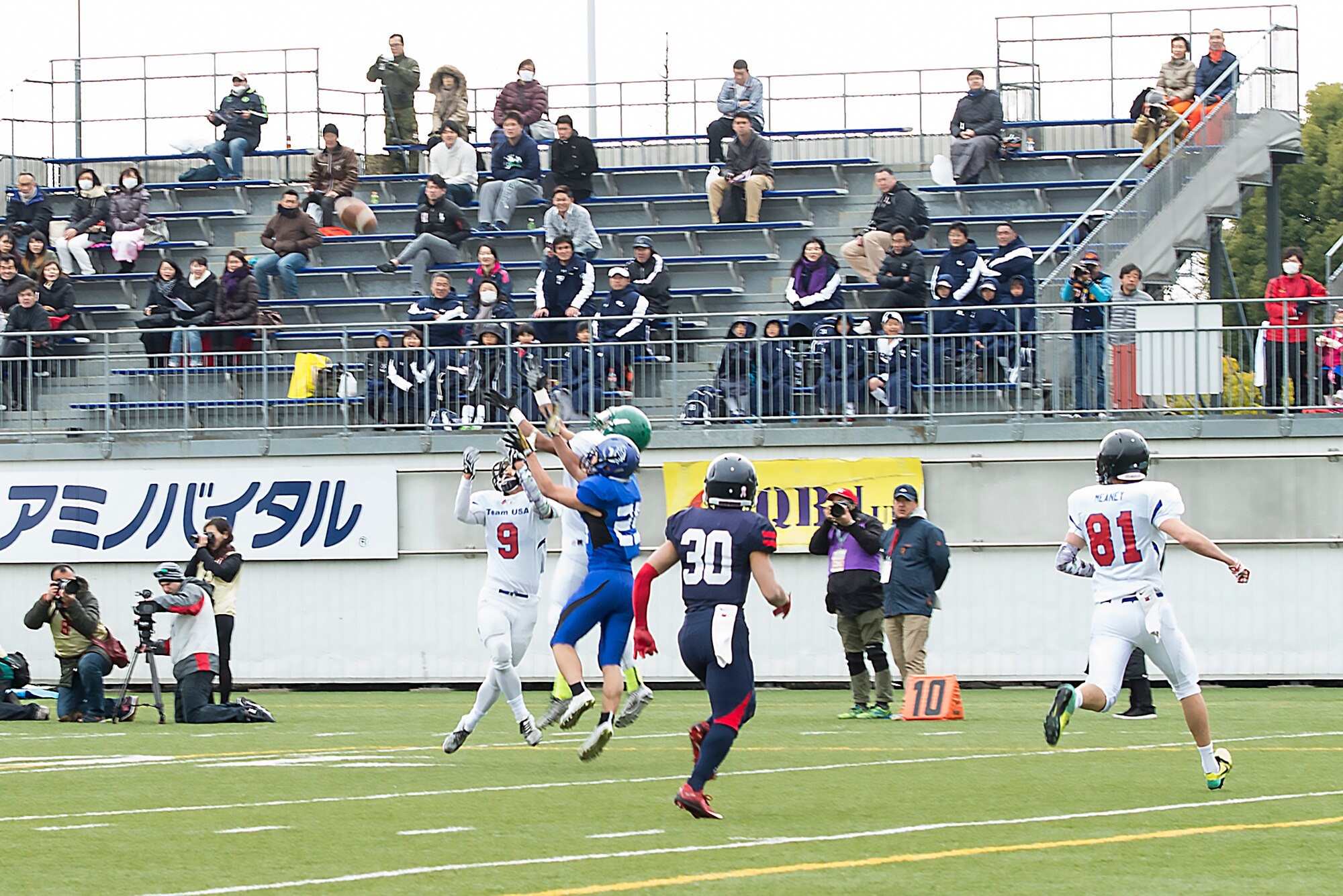 Players jump to catch the ball during Tomodachi Bowl 2016 at Amino Vital Stadium, Tokyo, Japan, March 13, 2016. Team USA won the game with a final score of 26-6. (U.S. Air Force photo by Senior Airman David C. Danford/Released)
