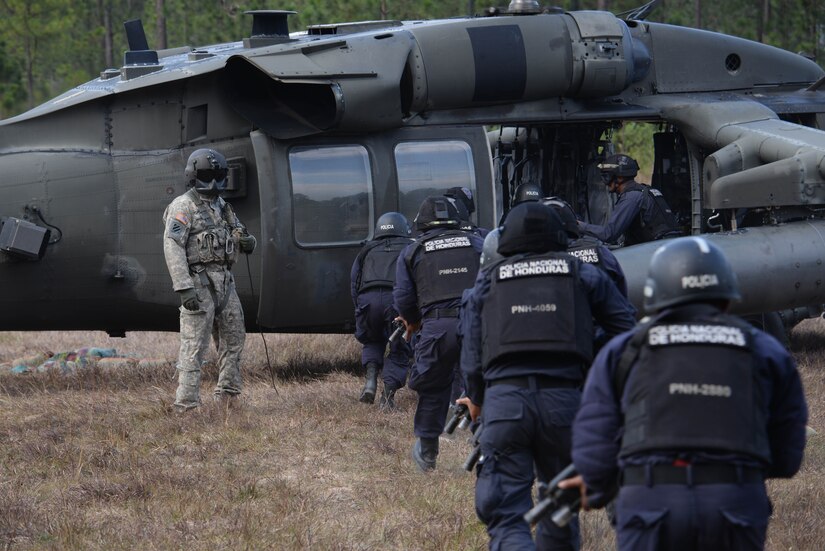 U.S. Army Sgt. 1st Class Christopher Smith, 1-228 Aviation Battalion crew chief, watches Honduran forces load a U.S. Army UH-60 Blackhawk helicopter Feb. 26, 2016, near Soto Cano Air Base, Honduras. The Hondurans conducted the training to prepare them for a personnel recovery exercise in which they would integrate with U.S. responding forces to provide security of a simulated downed. (U.S. Air Force photo by Staff Sgt. Westin Warburton/Released)