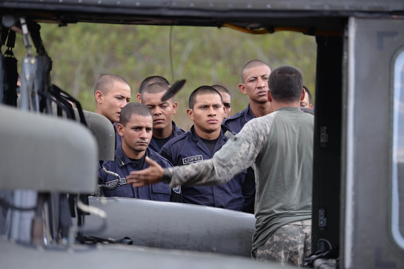 U.S. Army Sgt. Ruben Ramos, 1-228 Aviation Battalion crew chief, explains how to properly enter a U.S. Army UH-60 Blackhawk helicopter to Honduran response forces Feb. 26, 2016, near Soto Cano Air Base, Honduras, prior to a personnel recovery exercise. U.S and Honduran forces regularly train together to build their knowledge of techniques and capabilities in case they would ever need to operate together in real-world personnel recovery scenario. (U.S. Air Force photo by Staff Sgt. Westin Warburton/Released)