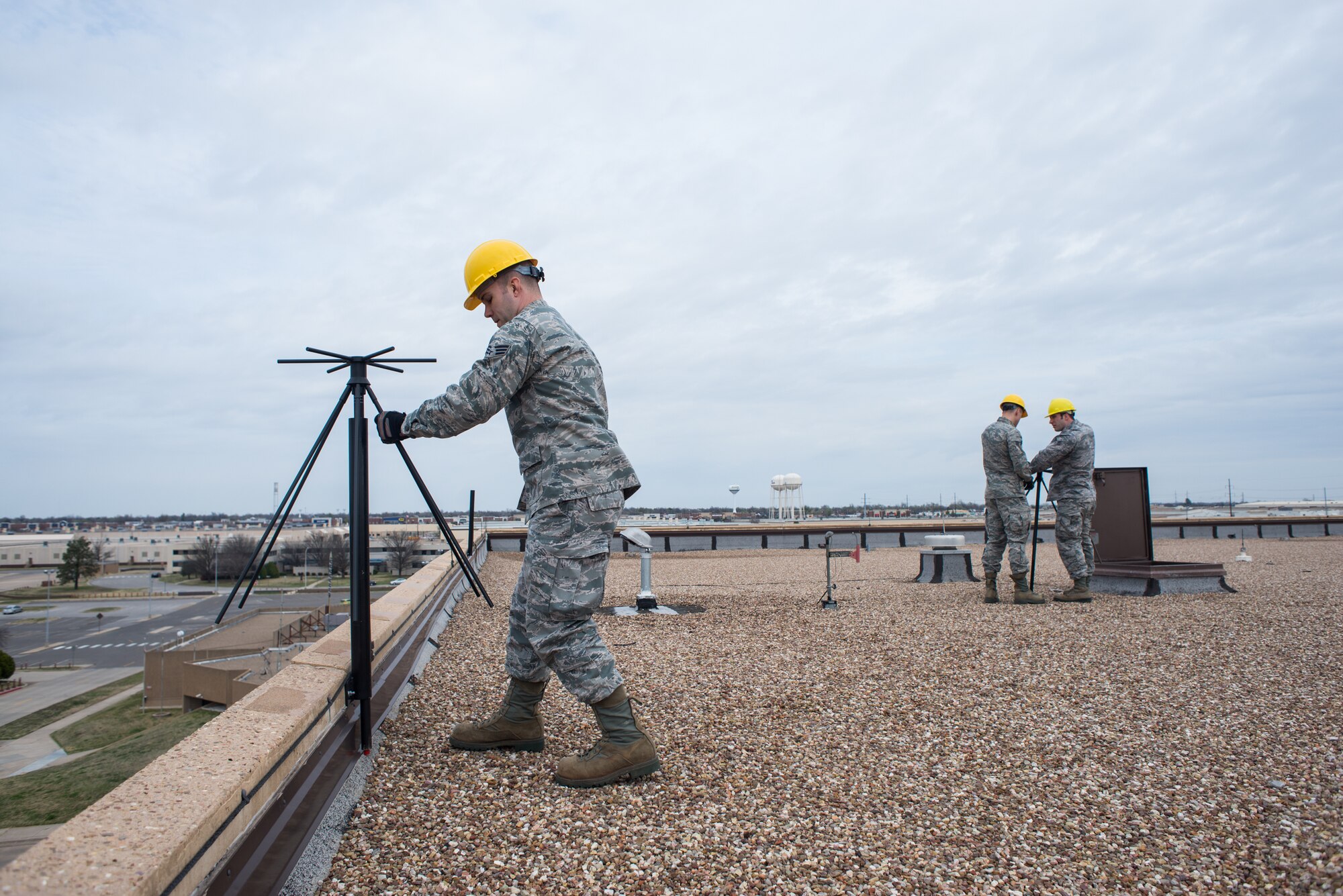 Senior Airman David Hopper, a cable and antenna technician with the 205th Engineering Installation Squadron from Will Rogers Air National Guard Base in Oklahoma City, moves a UVU-200 dual-band base station antenna to its position near a roof’s ledge, March 6, 2016, at Tinker Air Force Base in Oklahoma City. Hopper was a part of one of the two teams from the 205 EIS guard unit that worked to setup and repair antennas for active-duty squadrons at Tinker AFB.