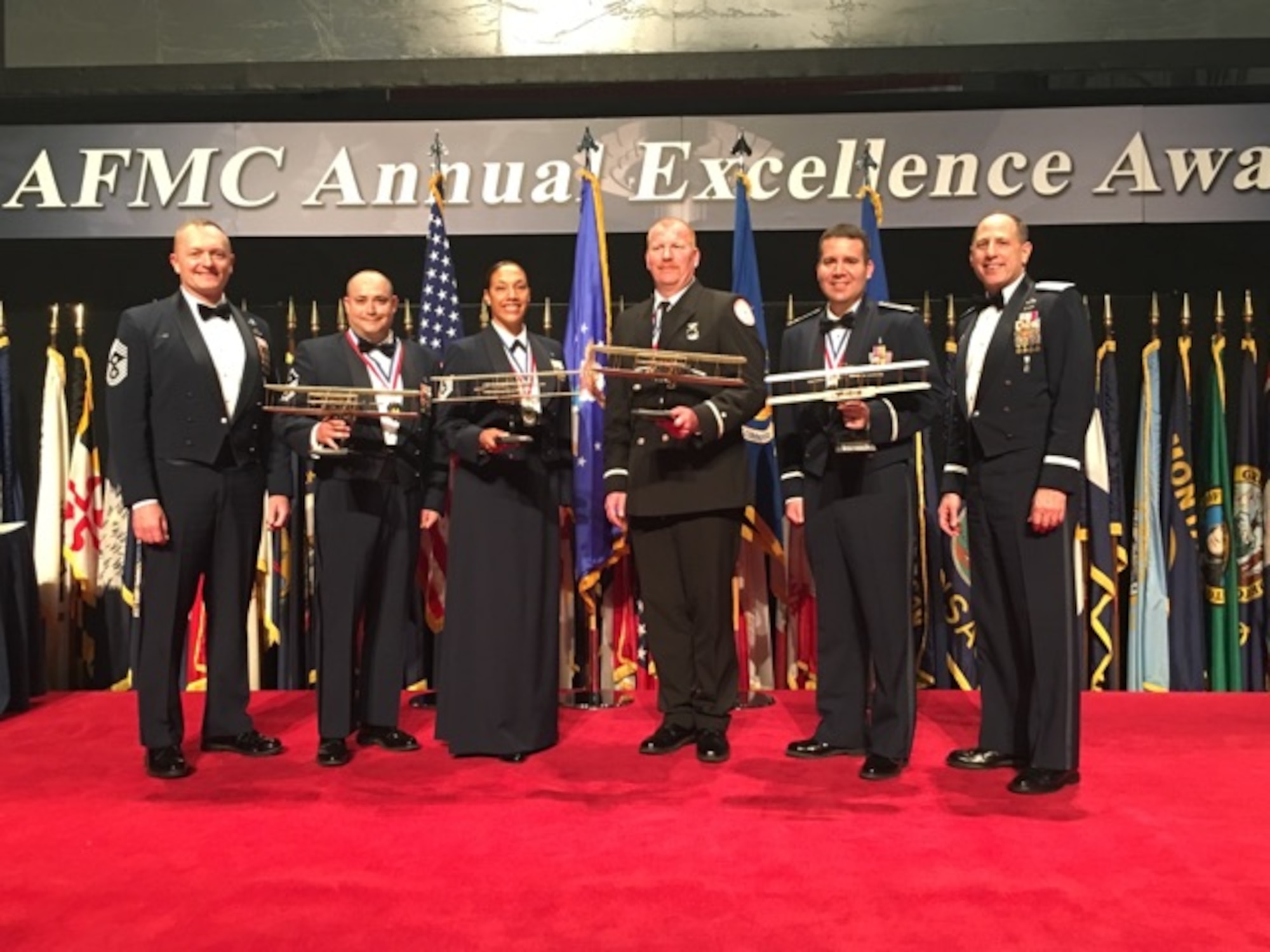 AFSC’s Air Force Materiel Command's 2015 Annual Excellence Award winners gather with ASMC leadership after the awards ceremony March 9, 2016, on Wright-Patterson AFB.
From left are Chief Master Sgt. Jason L. France, AFSC Command Chief; Master Sgt. Brian Partido, winner of the First Sergeant category; Technical Sgt. Kasmir Alford, winner of the Non-Commissioned Officer category; Mr. Steven Smith, winner of the Civilian category I; Maj. David Jarnot, winner of the Field Grade Officer category; and Lt. Gen. Lee K Levy II, AFSC Commander.
