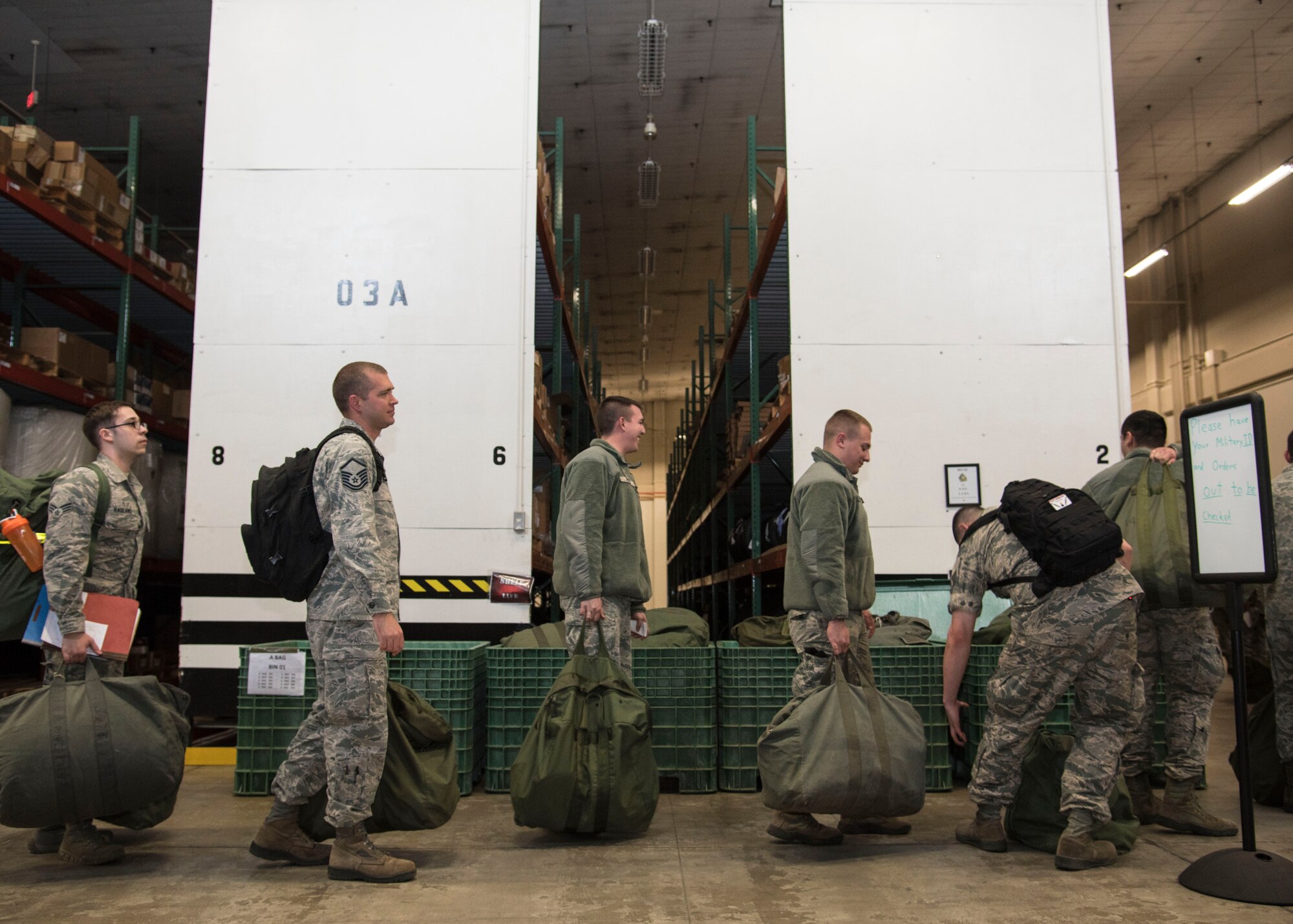 U.S Air Force Airmen line up during a mock Personnel Deployment Function at Misawa Air Base, Japan, March 15, 2016. After being cleared by PDF personnel and retrieving individual protective equipment, deploying Airmen await the weighing of their cargo for shipment. This ensures supplies loaded onto aircraft are properly balanced. (U.S. Air Force photo by Airman 1st Class Jordyn Fetter)