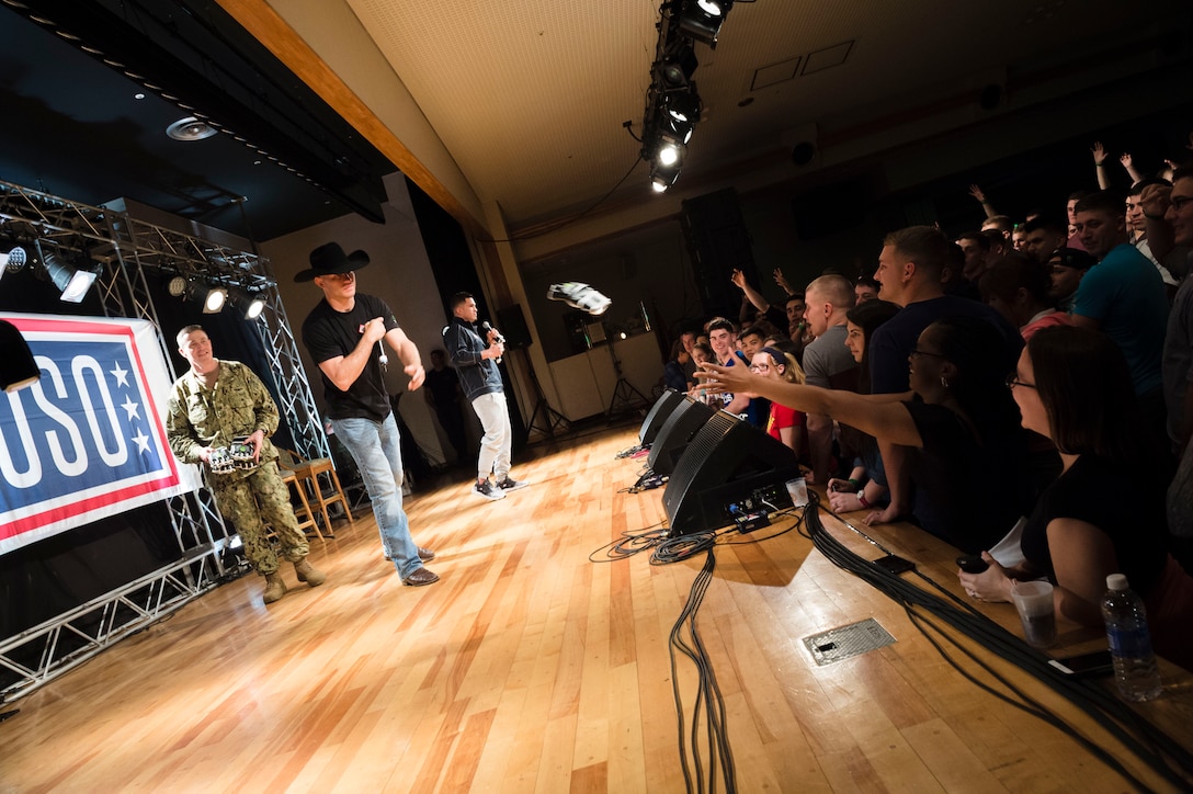 UFC fighter Donald "Cowboy" Cerrone tosses fighting gloves to troops and family members at a USO spring tour show on Camp Hansen, Japan, March 13, 2016. DoD photo by Army Staff Sgt. Sean K. Harp