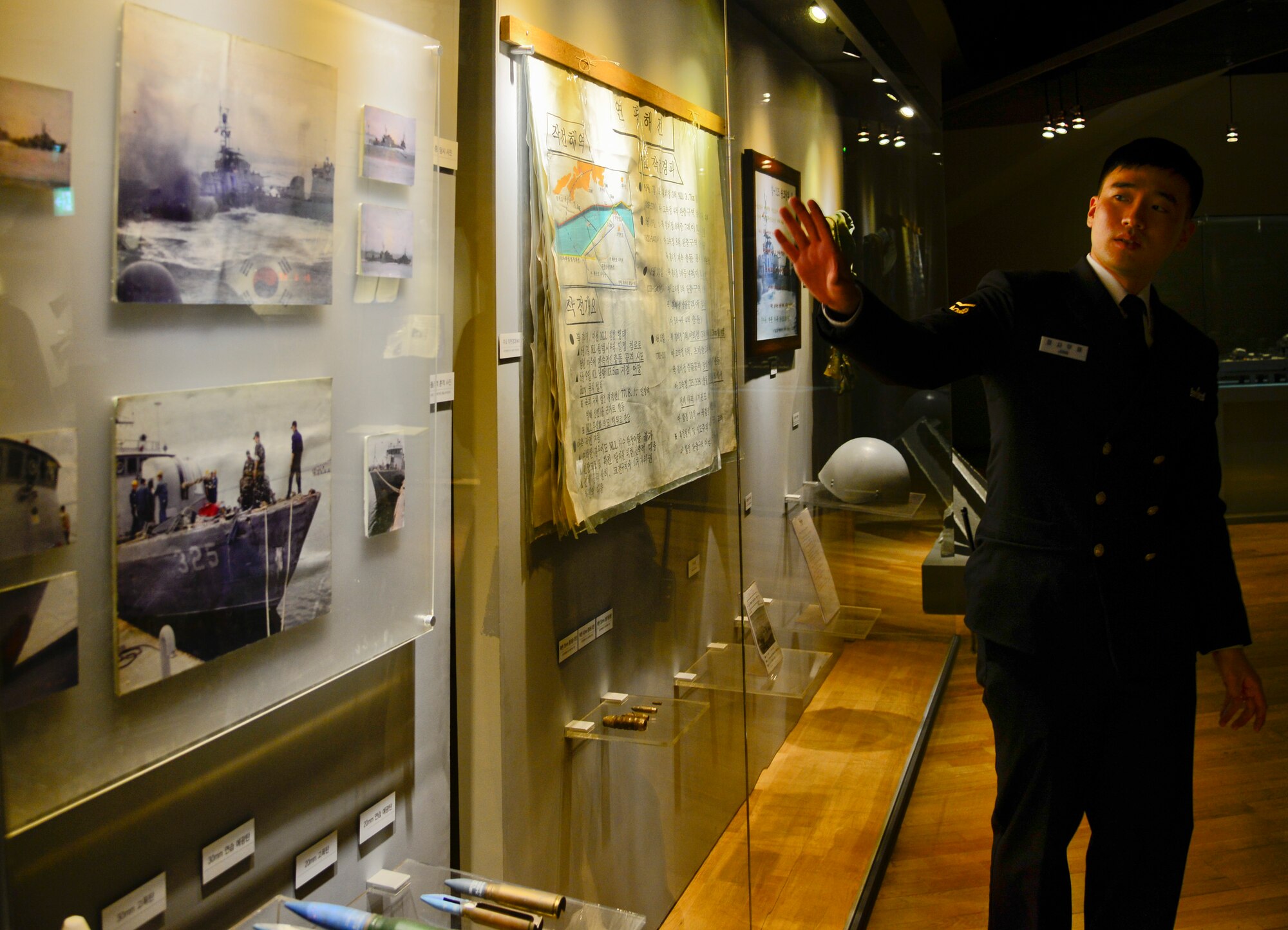 Republic of Korea Navy Petty Officer 1st Class Jung, Samuel, shows photos from the Yeonpyeong Sea Battles in the West Sea Protection Hall at the ROK Navy 2nd Fleet Command in Pyeongtaek-si, Gyeonggi-do Province, on Feb. 26, 2016. The sea battles took place June 15, 1999, and June 29, 2002, and are two of recent attacks on South Korea from North Korea patrols. (U.S. Air Force photo by Senior Airman Kristin High/Released)