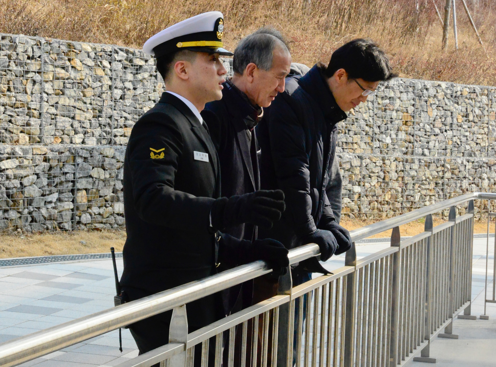Republic of Korea Navy Petty Officer 1st Class Jung, Samuel speaks with Yi, Chong Kun and Pak, Yong Hui, 51st Fighter Wing public affairs community relations liaisons, about the Yeonpyeong Sea Battles and the attack on ROK Navy ship Cheonan at the ROK Navy 2nd Fleet Command in Pyeongtaek-si, Gyeonggi-do Province on Feb. 26, 2016. The incidents are some of the recent attacks Republic of Korea from North Korea patrols. (U.S. Air Force photo by Senior Airman Kristin High/Released)