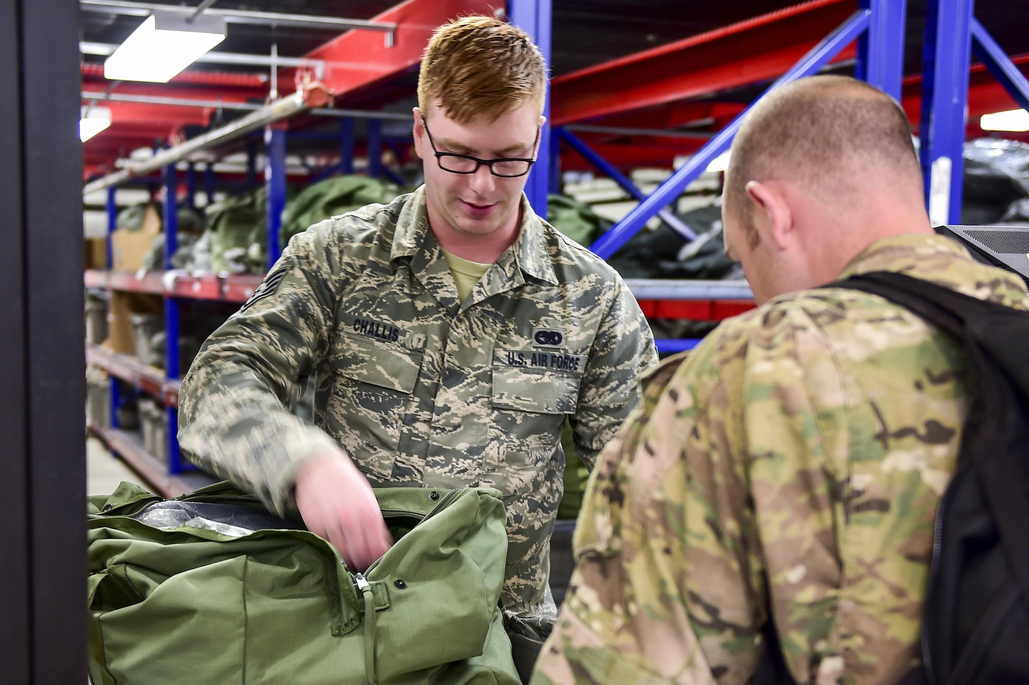 Staff Sgt. Kyle Challis, an individual protective equipment supervisor with the 1st Special Operations Logistics Readiness Squadron, issues a mobility bag at the Deployment Control Center, Hurlburt Field, Fla., March 14, 2016. Air Commandos participated in a mobility exercise to showcase their ability to deploy at a moment’s notice ‘Any Time, Any Place.’ (U.S. Air Force photo by Senior Airman Jeff Parkinson)