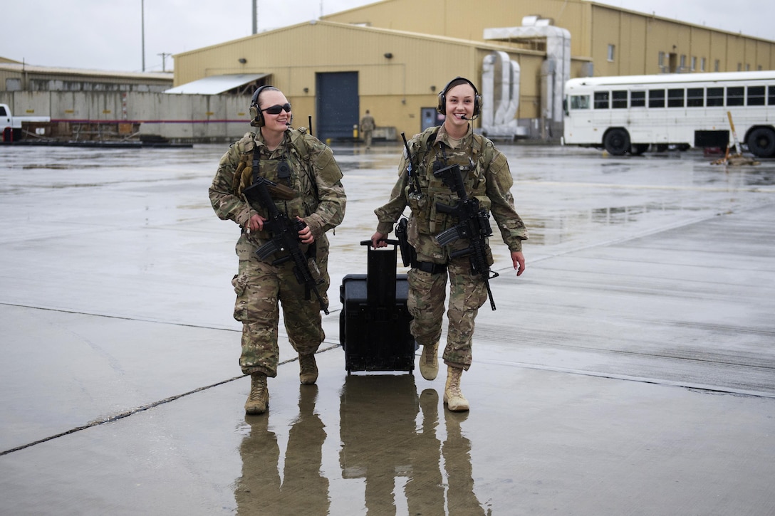 Air Force Senior Airman Bre Balk, left, and Airman 1st Class Alexandra Powell walk to a C-130J Super Hercules aircraft with their equipment before a mission on Bagram Airfield, Afghanistan, March 16, 2016. Air Force photo by Tech. Sgt. Robert Cloys