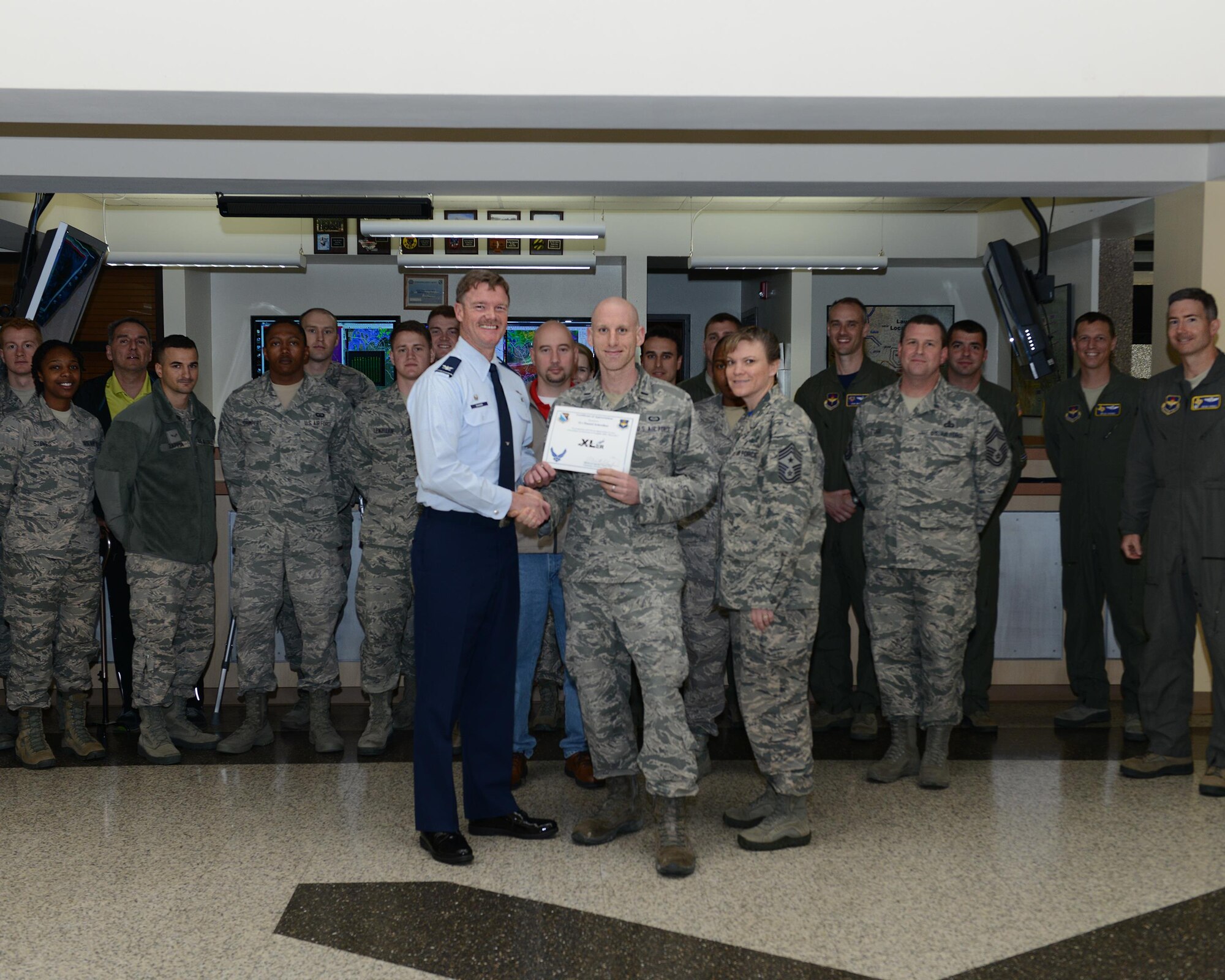 First Lt. Daniel Schreiber, center, 47th Operations Support Squadron weather flight commander, accepts the “XLer of the Week” award from Col. Thomas Shank, left, 47th Flying Training Wing commander, and Chief Master Sgt. Teresa Clapper, right, 47th FTW command chief, here, Mar. 11, 2016. The XLer is a weekly award chosen by wing leadership and is presented to those who consistently make outstanding contributions to their unit and Laughlin. (U.S. Air Force photo by Senior Airman Jimmie D. Pike)