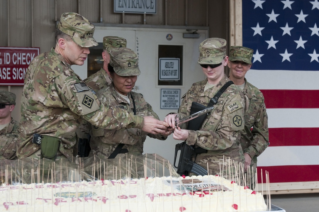 Sgt. 1st Class Sagrario Carlson, 311th Expeditionary Sustainment Command, the oldest Army Reserve soldier and Spc. Megan Biggs, 652nd Regional Support Group, the youngest Army Reserve soldier stationed at Kandahar Airfield, cut the 105th Army Reserve birthday cake with Lt. Gen. Jeffrey W. Talley, commander of the Army Reserve, April 26 during a ceremony. (U.S. Army photo by Sgt. Phillip Valentine, 311th Expeditionary Sustainment Command Public Affairs)