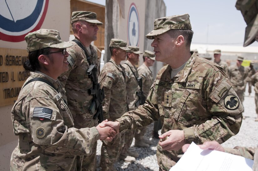 U.S. Army Lt. Gen. Jeffrey Talley, right, the chief of the Army Reserve, presents a challenge coin to Spc. Raquel Luis during an awards ceremony at Kandahar Airfield in Kandahar province, Afghanistan, April 27, 2013. Luis was assigned to the 311th Sustainment Command. (U.S. Army photo by Sgt. Phillip Valentine/Released)