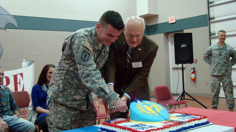 Iowa Army Reserve soldier Spc. Joseph Davison, most junior soldier assigned to 1st battalion, 383rd Training Support Battalion, 166th Aviation Brigade, First Army Division West – based at Fort Des Moines, cuts a birthday cake with Mayor Pro Tem T.H. Bob Mahaffey during the 106th birthday celebration of the Army Reserve on April 5. The honor of the most senior enlisted to cut the cake with the most junior soldier was extended to Mahaffey. (Photo by Capt. Mark Butcher)

