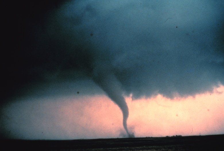 Tornado with dust and debris cloud forming at surface.
