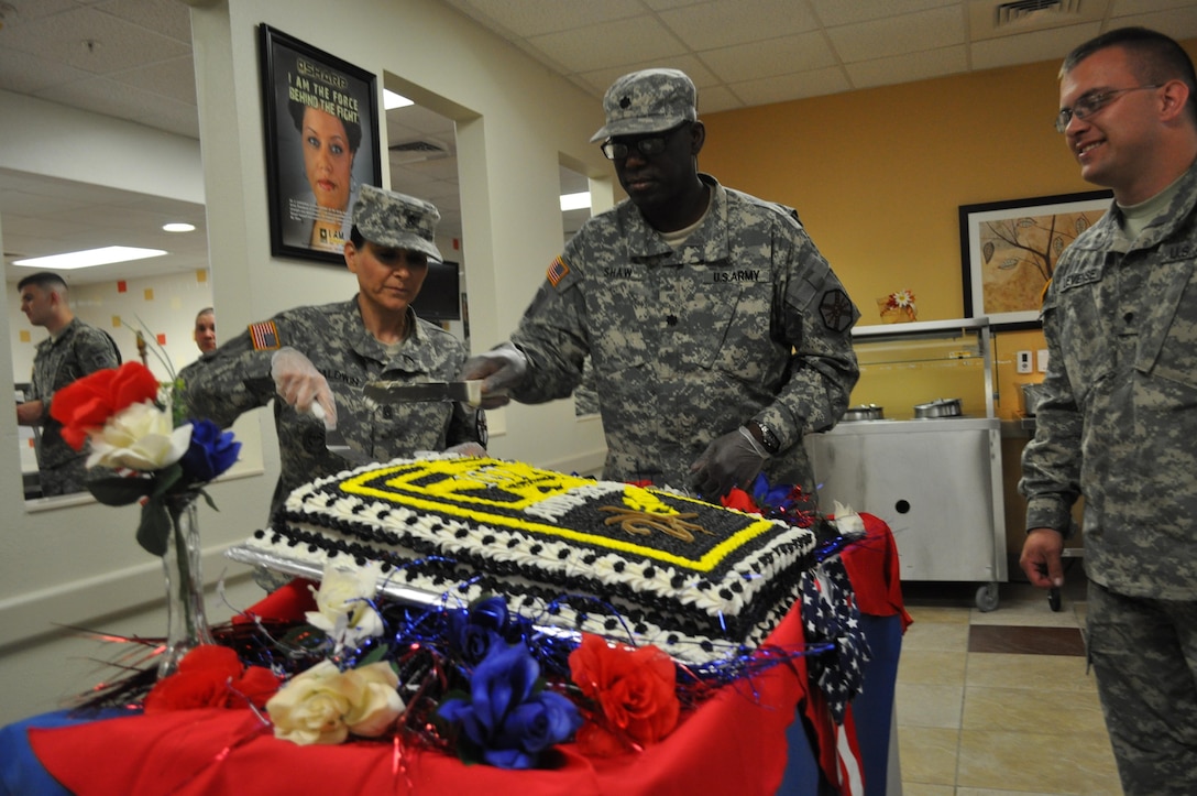 Command Sgt. Maj. Jane P. Baldwin, command sergeant major, 2206th Mobilization Support Battalion, left, and Lt. Col. Bradford Shaw, commander, 2206th MSB, center, cuts the birthday cake celebrating 107 years of the U.S. Army Reserve, April 23, at the Maj. Chester Garret Dining Facility on McGregor Range, N.M. Far right, Spc. Brandon Lievense, chaplain’s assistant, looks on before distributing pieces of cake during the lunch service.