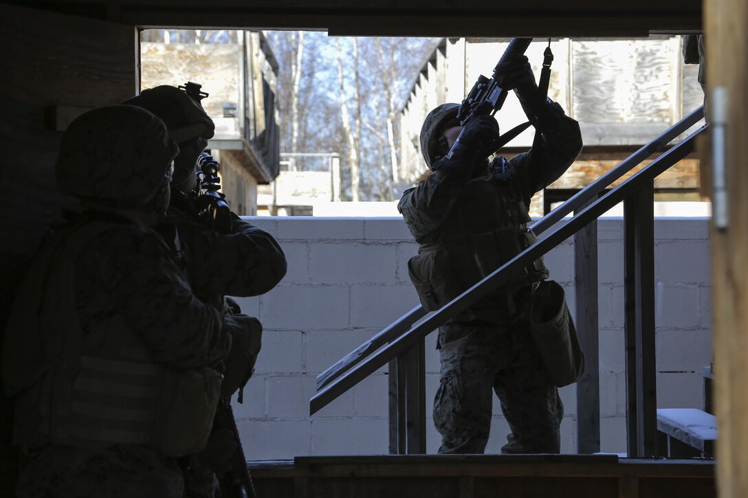 Marines move cautiously up a staircase before assaulting and clearing a complex during urban operations training on Joint Base Elmendorf-Richardson, Alaska, March 6, 2016. Air Force photo by Alejandro Pena