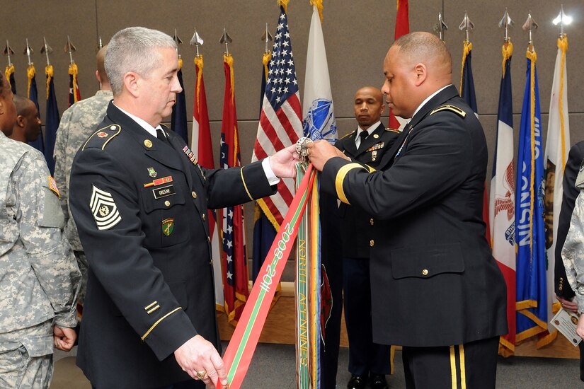 Command Sgt. Maj. Kevin Greene, command sergeant major, 85th Support Command; left, and Brig. Gen. Gracus K. Dunn, commanding general, 85th Support Command and deputy commanding general for support, First Army Division-West; add the Army Superior Unit Award streamer to the unit’s colors during a formal ceremony at the unit’s headquarters during an Army Reserve birthday celebration on April 5. The Army Reserve’s birthday is on April 23.
(U.S. Army photo by Sgt. 1st Class Anthony L. Taylor/Released)