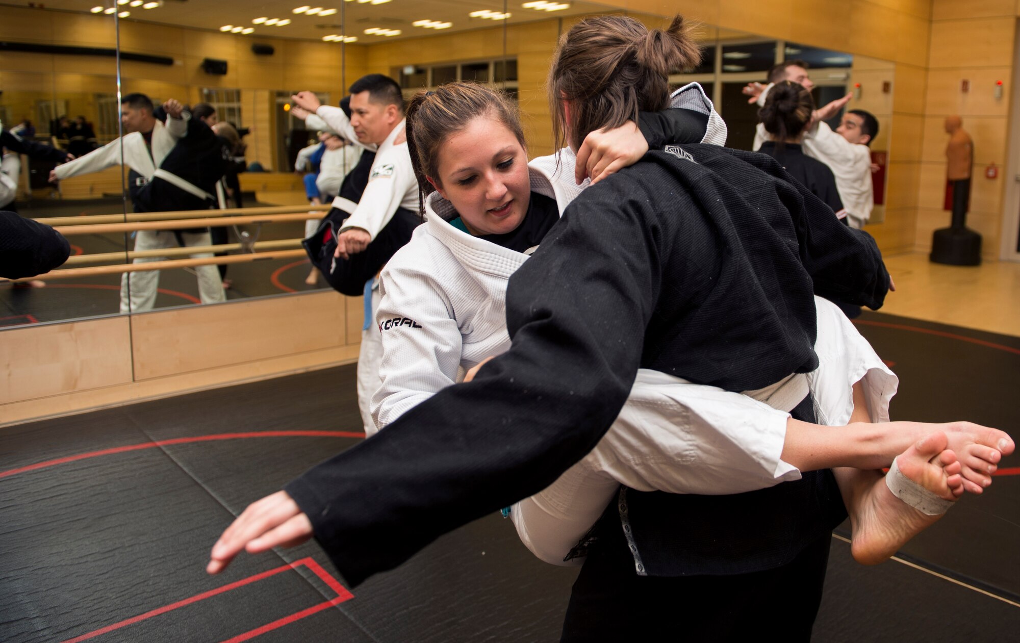 Mariah Johnson, a 52nd Force Support Squadron value-added tax officer, climbs on 2nd Lt. Arianna Niro, a 52nd Communications Squadron plans and implementations deputy flight commander, during a jiujitsu drill exercise at Spangdahlem Air Base, Germany, March 8, 2016. (U.S. Air Force photo/Airman 1st Class Timothy Kim)