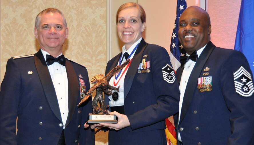Master Sgt. Cortney Shank, center, accepts the 302nd Airlift Wing’s 2015 Outstanding First Sergeant of the Year award from Col. Jack H. Pittman, Jr., left, 302nd AW commander, and Chief Master Sergeant Otis L. Jones, 302nd AW command chief master sergeant. Shank received the award at the 302nd AW annual awards dinner March 5, 2016. (U.S. Air Force photo/2nd Lt. Stephen Collier)