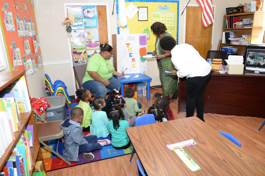 Shirley Burke-Mitchell, Huntsville Center contract specialist, and Jacqueline White, Huntsville Center electrical engineer, learn about a pre-kindergarten class's group project during the First Baptist Child Development Center & Academy science fair.
