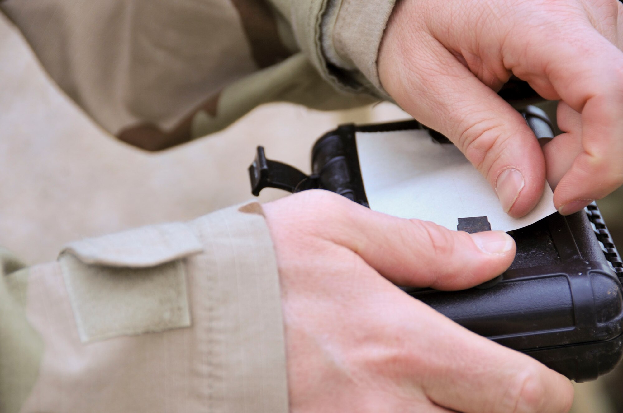 An Airman attaches M-8 paper to a liquid detection post during chemical, biological, radiological and nuclear defense survival skills training at Barksdale Air Force Base, La., March 8, 2016. During training, Airman 1st Class Victoria Hammond, 2nd Civil Engineer Squadron emergency manager, taught Airmen the importance of contamination avoidance. Ways to avoid contamination include covering assets, regularly inspecting gear, monitoring zone transition points, and properly disposing contaminated waste. (U.S. Air Force photo/Senior Airman Amanda Morris)