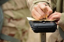 An Airman writes the date on M-8 paper during chemical, biological, radiological and nuclear defense survival skills training at Barksdale Air Force Base, La., March 8, 2016. The dates provide Airman with a reference when inspecting the paper for contamination. (U.S. Air Force photo/Senior Airman Amanda Morris)