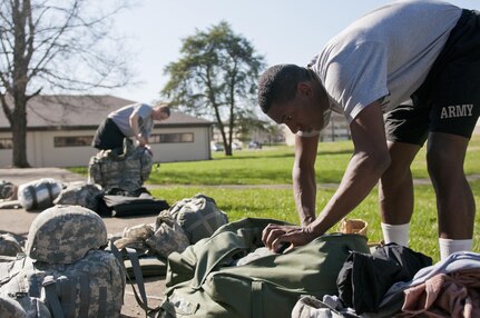 Spc. Xavier Mantock, a competitor of the 316th Sustainment Command (Expeditionary) Best Warrior Competition, searches for required items during a layout formation for the competition at Fort Knox, Ky., March 15, 2016. (U.S. Army photo by Staff Sgt. Dalton Smith/Released)