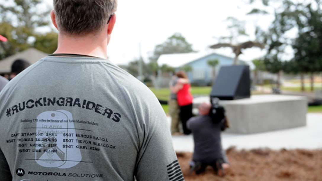 A supporter looks on as the opening ceremony of a 770-mile ruck continues near the soon-to-be-completed memorial at Navarre Beach Park in Florida. The 770-mile ruck from Navarre, Florida, to Marine Corps Base Camp Lejeune, North Carolina is in honor of 11 service members who died in a helicopter crash one year ago. For the next 10 days, the ruckers will walk in seven teams and trade off every 10-11 miles, about 110 miles each, until they get there.