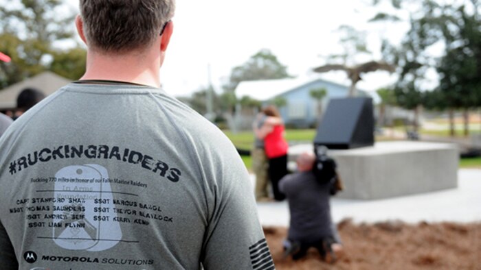 A supporter looks on as the opening ceremony of a 770-mile ruck continues near the soon-to-be-completed memorial at Navarre Beach Park in Florida. The 770-mile ruck from Navarre, Florida, to Marine Corps Base Camp Lejeune, North Carolina is in honor of 11 service members who died in a helicopter crash one year ago. For the next 10 days, the ruckers will walk in seven teams and trade off every 10-11 miles, about 110 miles each, until they get there.