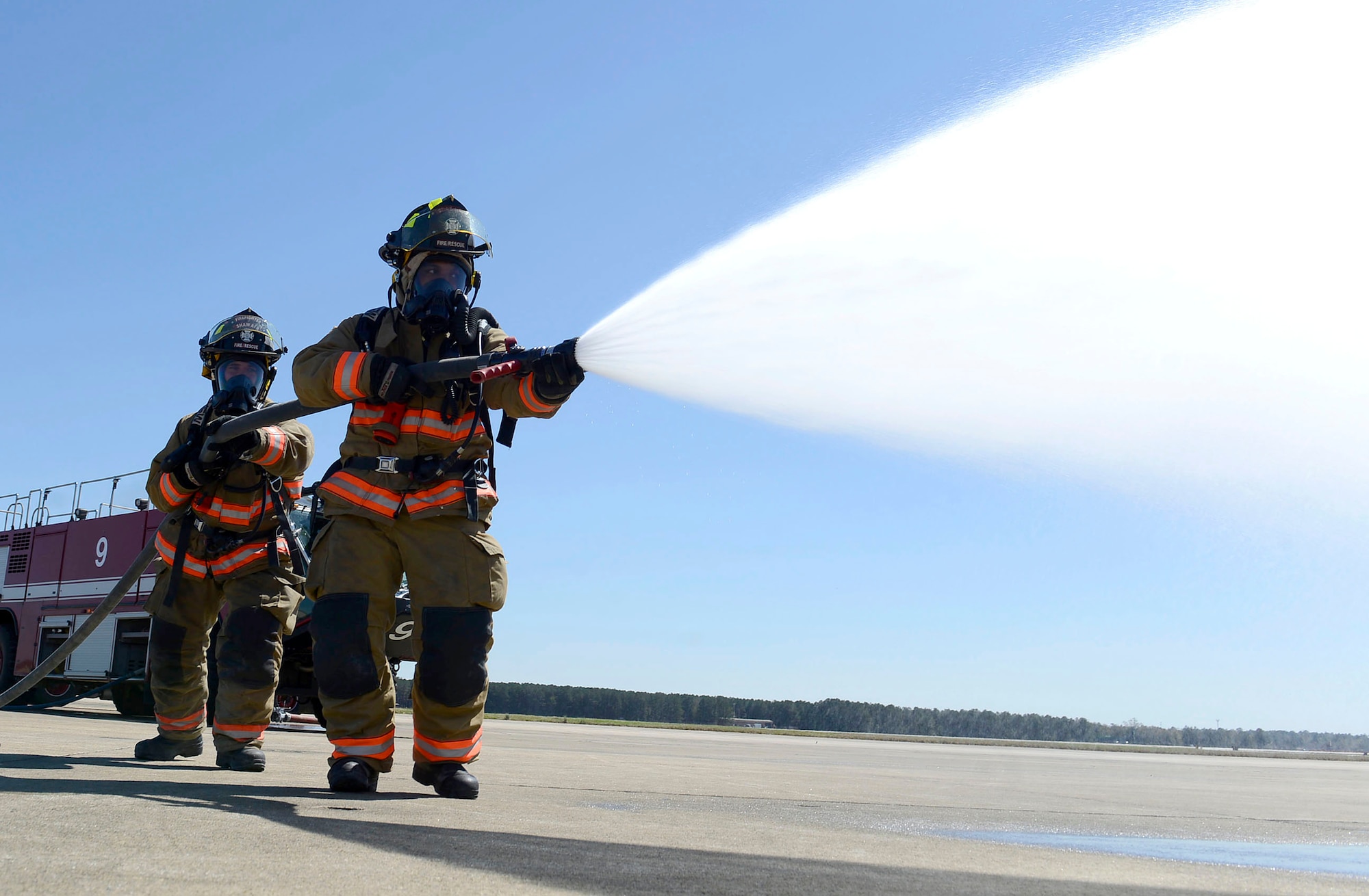 U.S. Air Force Senior Airman Joan Ortega, 20th Civil Engineer Squadron firefighter and Airman 1st Class John Derboghossian, 20th CES firefighter apprentice, use an inch and three quarter attack line hose while training on the flightline at Shaw Air Force Base, March 15, 2016. The fire hose has the power to shoot over 100 pounds of water per minute and helps in the rapid clearing of fire on buildings, vehicles and aircrafts. (U.S. Air Force photo by Airman 1st Class Christopher Maldonado)