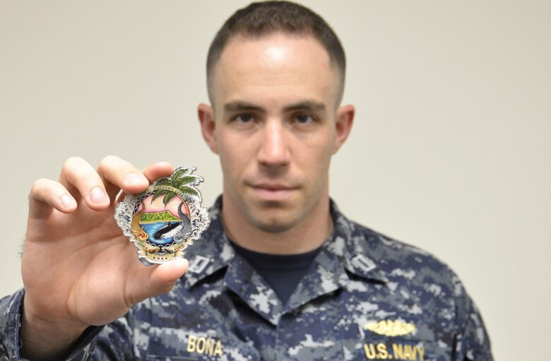 Lieutenant Nick Bona presents the 116th Pacific Fleet Submarine Force birthday ball’s challenge coin. The ball celebrates 116 years of distinguished service by the submarine force. (U.S. Navy photo by Lieutenant Junior Grade Samuel Boyle/Released)
