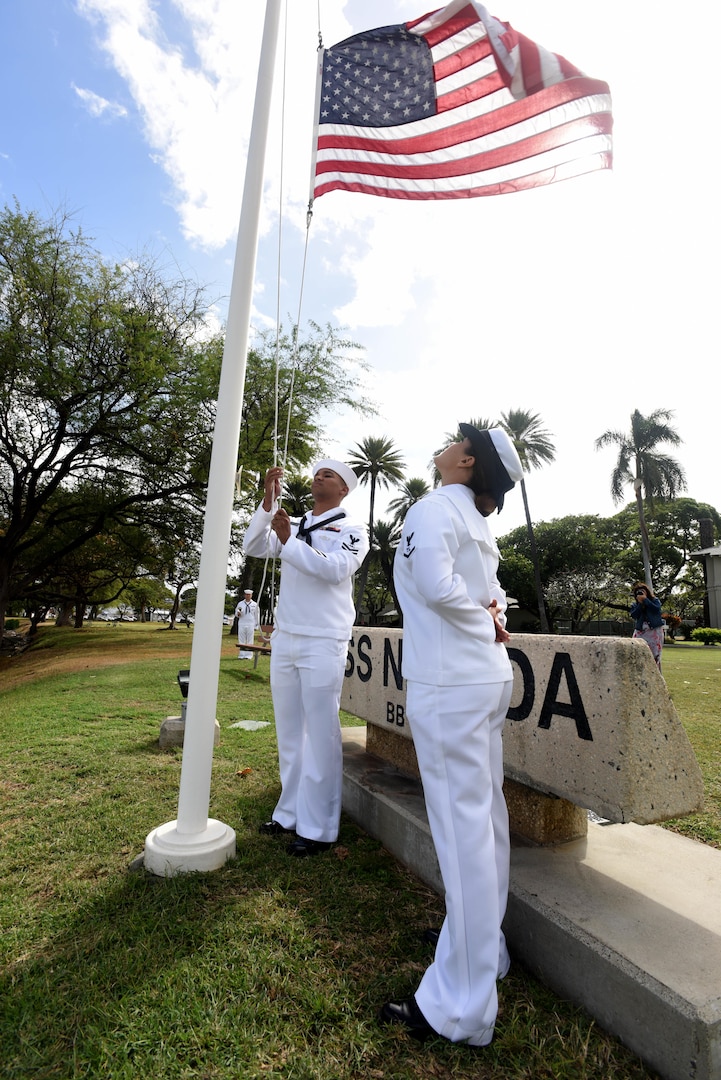 160311-N-QL961-082 PEARL HARBOR (Mar. 11, 2016) Culinary Specialist 2nd Class David Johnson, left, and Operations Specialist 3rd Class Jasmine Bencid, both members of the Joint Base Pearl Harbor-Hickam (JBPHH) color guard, lower the national ensign during a commemoration ceremony for the USS Nevada's (BB 36) 100th anniversary of its commissioning at the USS Nevada memorial on JBPHH. The ceremony was conducted at the Nevada memorial simultaneously as a similar ceremony was being held in Carson City, Nevada. (U.S. Navy photo by Mass Communication Specialist 1st Class Phillip Pavlovich/Released)