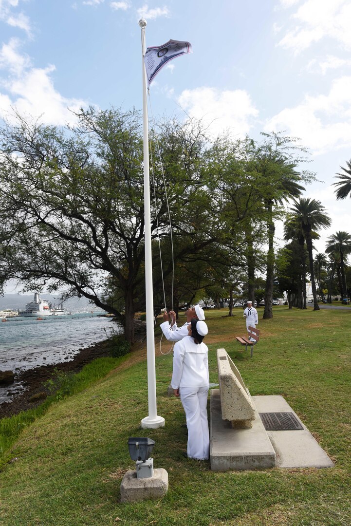 160311-N-QL961-151 PEARL HARBOR (Mar. 11, 2016) Culinary Specialist 2nd Class David Johnson, left, and Operations Specialist 3rd Class Jasmine Bencid, both members of the Joint Base Pearl Harbor-Hickam (JBPHH) color guard, raise the USS Nevada (BB 36) battleship flag during a commemoration ceremony for the ship's 100th anniversary of its commissioning at the USS Nevada memorial on JBPHH. The ceremony was conducted at the Nevada memorial simultaneously as a similar ceremony was being held in Carson City, Nevada. (U.S. Navy photo by Mass Communication Specialist 1st Class Phillip Pavlovich/Released)