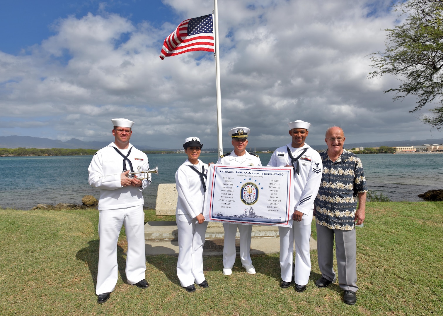 160311-N-QL961-165 PEARL HARBOR (Mar. 11, 2016) Sailors assigned to Joint Base Pearl Harbor-Hickam, and Jim Taylor, Navy Region Hawaii Pearl Harbor Survivor liaison, right, pose for a group photo with the USS Nevada (BB 36) Battleship Flag in front of the ship's memorial following its 100th anniversary of its commissioning ceremony. The ceremony was conducted at the Nevada memorial simultaneously as a similar ceremony was being held in Carson City, Nevada. (U.S. Navy photo by Mass Communication Specialist 1st Class Phillip Pavlovich/Released)
