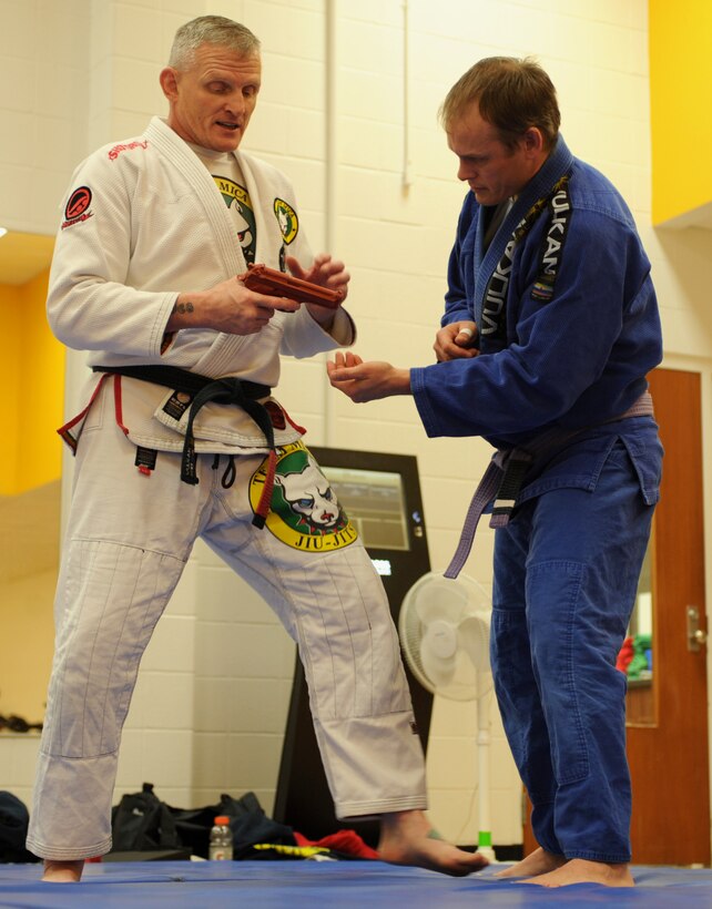 U.S. Army National Guard Sgt. 1st Class Michael Huitema, 109th Regional Support Group detachment sergeant, left, and Joe Reiter, Lead, S.D., paramedic, right, demonstrate techniques to disarm an opponent with a firearm during a women’s self-defense training seminar at Ellsworth Air Force Base, S.D., March 14, 2016. Huitema demonstrated how to deflect a weapon and safely disarm the assailant. (U.S. Air Force photo by Airman 1st Class Denise M. Nevins/Released)