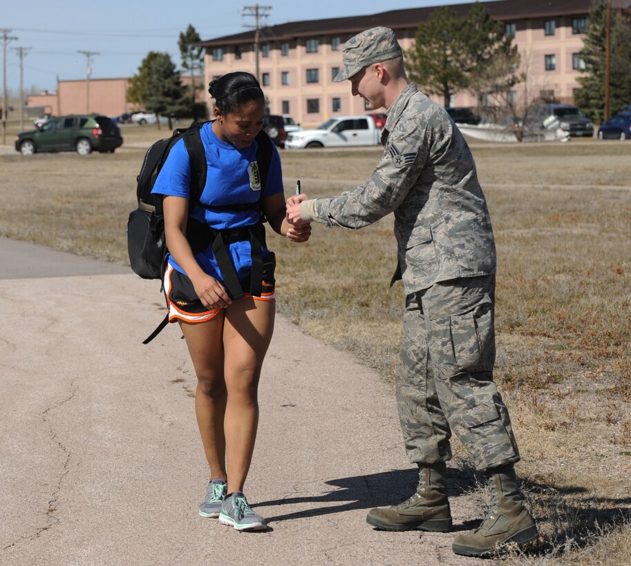 Airman 1st Class Sadie Colbert, 28th Bomb Wing Public Affairs photojournalist, gets her lap counter checked off during the Rucksack March 10K at Ellsworth Air Force Base, S.D., March 11, 2016. The event was hosted by the Bellamy Fitness Center as a way to promote physical fitness and team cohesion. (U.S. Air Force photo by Airman 1st Class Denise M. Nevins/Released)
