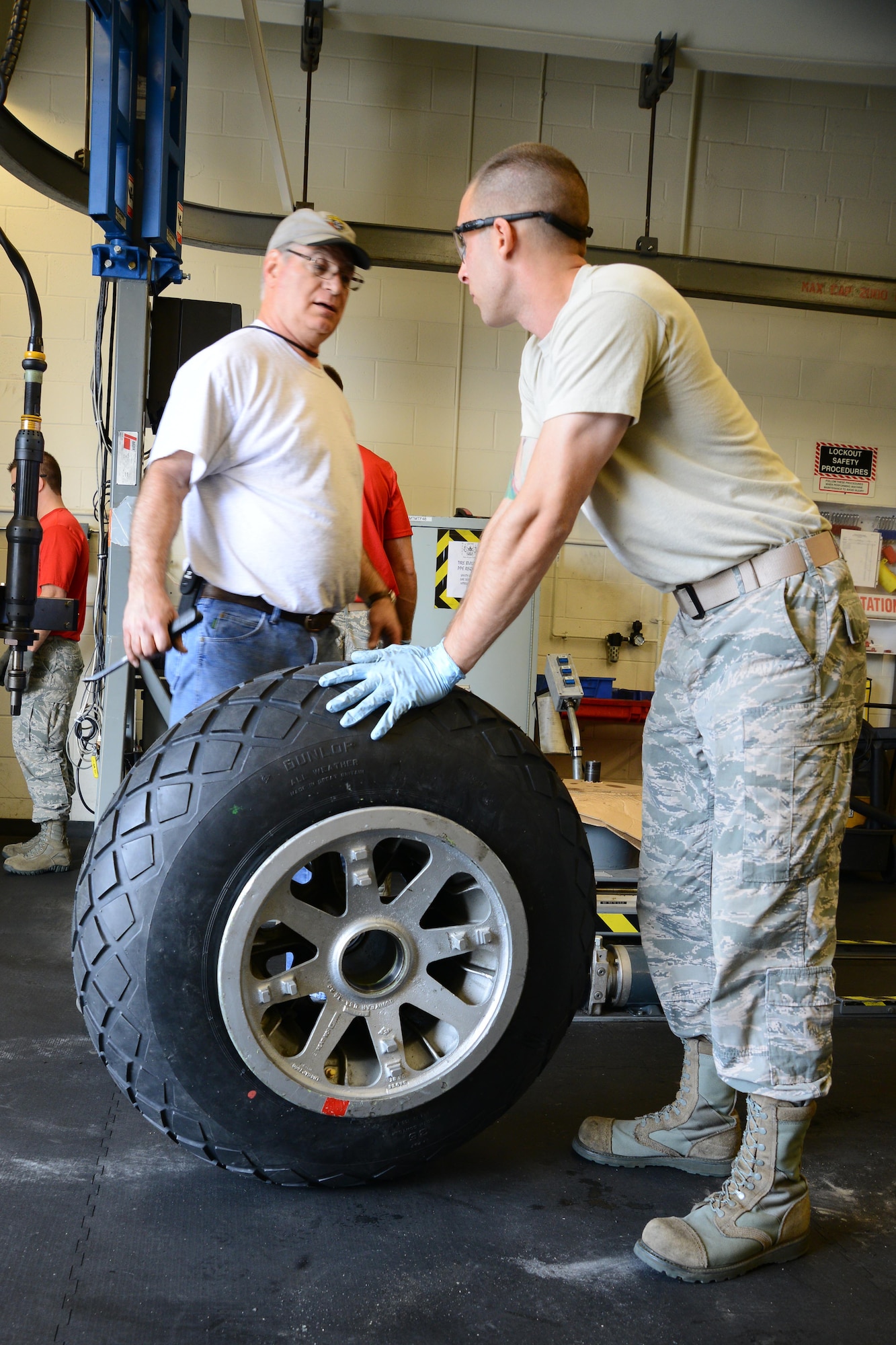 Staff Sgt. Andrew Lapusnak, 22nd Maintenace Squadron wheel and tire section inspection craftsman, rolls a B-29 Stratofortress wheel to be aired up, March 11, 2016, at McConnell Air Force Base, Kan.  The wheel will replace an old tire for the restoration of ‘Doc.’ (U.S. Air Force photo/Airman 1st Class Christopher Thornbury)