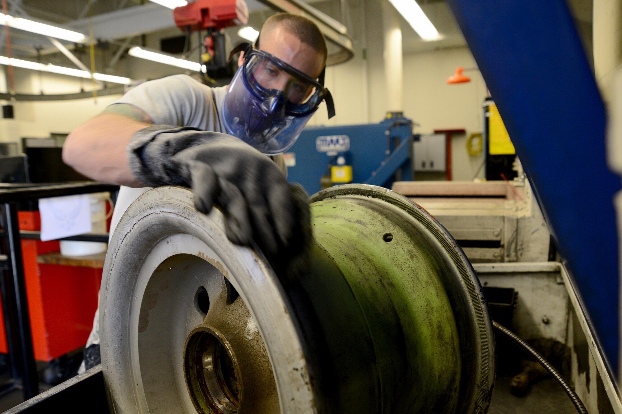 Staff Sgt. Andrew Lapusnak, 22nd Maintenace Squadron wheel and tire section inspection craftsman, cleans a B-29 Stratofortress wheel so that a new tire can gets a good seal, March 11, 2016, at McConnell Air Force Base, Kan.  Cleaning the wheel  provides a good seal for the new tire that will replace an old tire for a restoration of ‘Doc.’ (U.S. Air Force photo/Airman 1st Class Christopher Thornbury) 