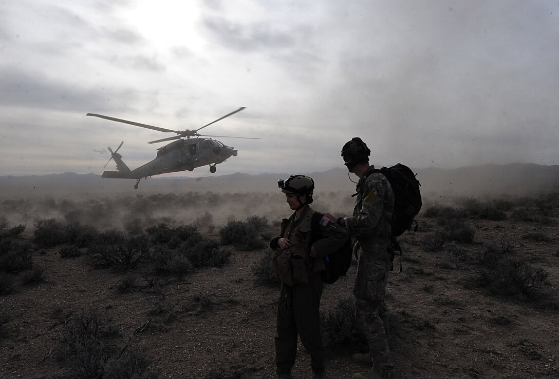 First Lt. Adria Trgovcich, 350th Air Refueling Squadron navigator, and Senior Airman Tyler Gillespie, 22nd Training Squadron Survival, Evasion, Resistance and Escape specialist, wait for a helicopter to land near Rachel, Nev. The Airmen participated in a personnel recovery mission as part of Red Flag 16-2. (U.S. Air Force photo/Senior Airman David Bernal Del Agua)