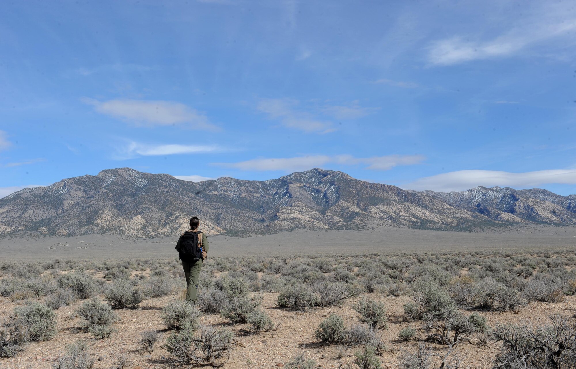 First Lt. Adria Trgovcich, 350th Air Refueling Squadron navigator, walks to a clear spot for a helicopter to land, March 9, 2016, in a mountain range near Rachel, Nev. Trgovcich participated in a personnel recovery exercise during Red Flag 16-2. (U.S. Air Force photo/Senior Airman David Bernal Del Agua)
