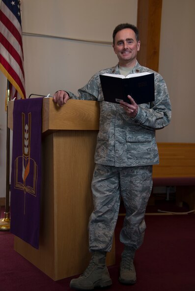 Major Lance Giannone, wing chaplain 5th Bomb Wing, poses at the altar at the Northern Lights Chapel at Minot Air Force Base, N.D., March 15, 2016. Church services are one of the many things that the chaplain corps offers to Airmen. (U.S. Air Force photo/Airman 1st Class Christian Sullivan)