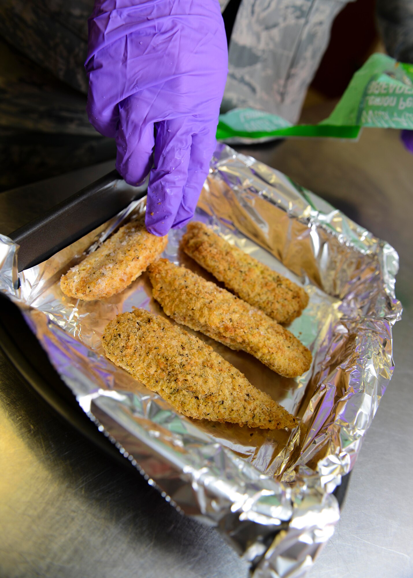 Senior Airman Kevin Moynihan, 31st Medical Support Squadron diet therapy technician, prepares chicken strips for inpatients, March 9, 2016, at Aviano Air Base, Italy. Nutritional medicine staff members prepare food for inpatients to ensure they receive the nutrition necessary during their hospitalization. (U.S. Air Force photo by Senior Airman Austin Harvill/Released)