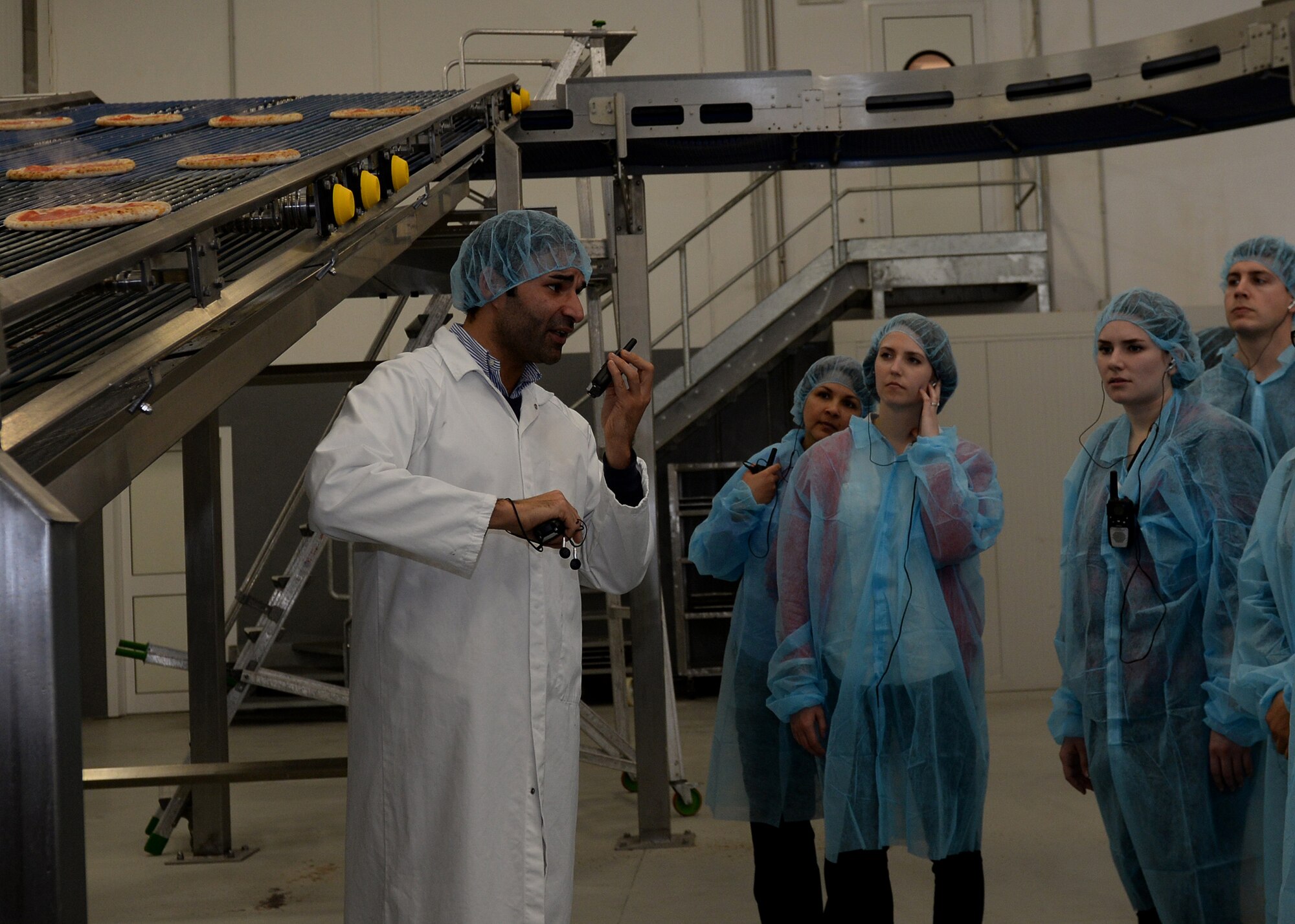 Officers from the 31st Logistics Readiness Squadron learn about making pizza during a pizza factory tour, March 14, 2016, in Meduno, Italy. The tour focused on building community relations and helped attendees better understand logistical planning. (U.S. Air Force photo by Airman 1st Class Cary Smith/Released) 