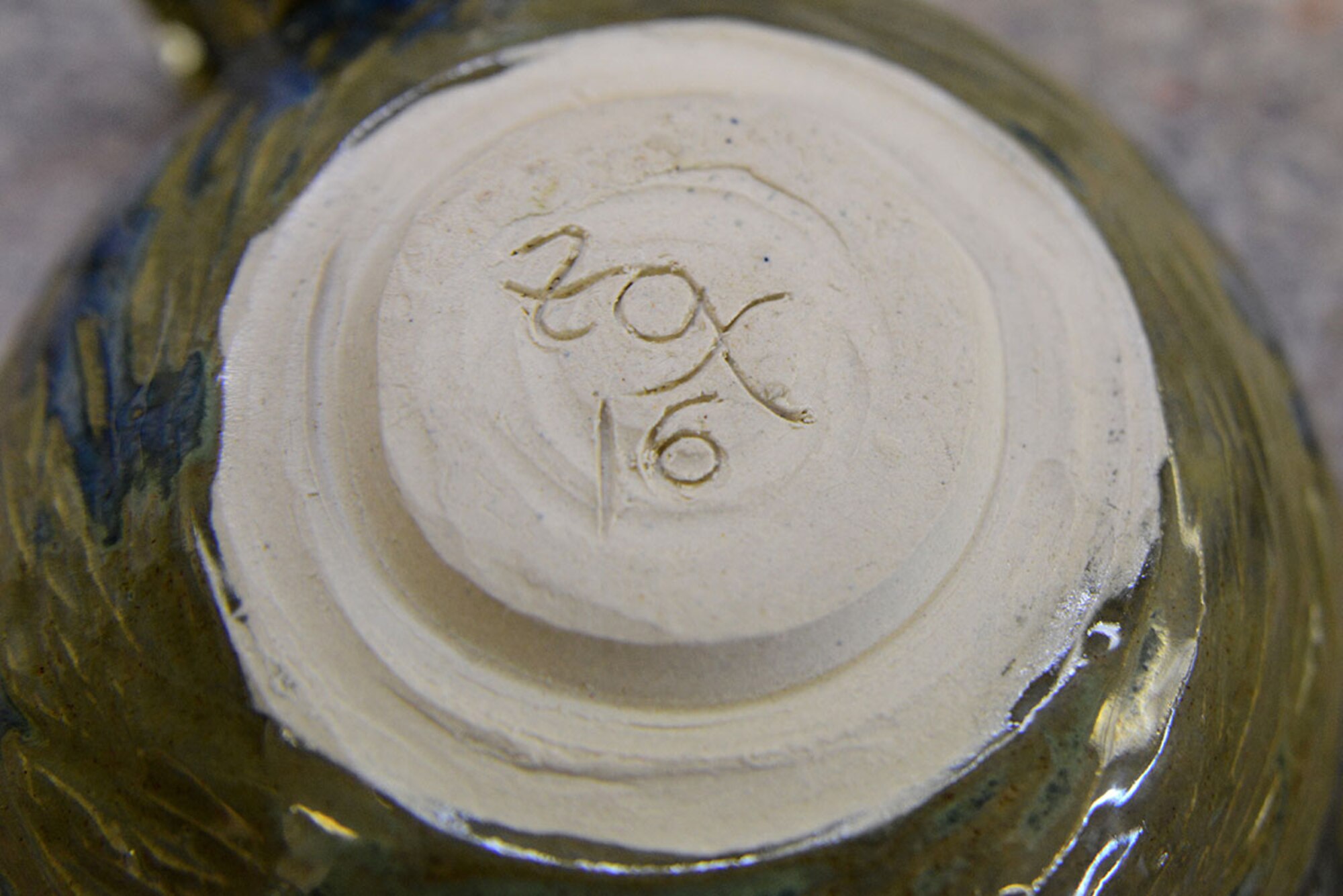 U.S. Coast Guard spouse Laura Fox leaves her signature at the bottom of her creations at the Polar Express Arts and Crafts Center at Joint Base Elmendorf-Richardson, Alaska, Feb. 28, 2016. Fox sometimes carves her signature before it dries or after the first visit to the kiln. Fox began creating pottery four years ago, but moved to Alaska seven months ago with her spouse Senior Chief Petty Officer Alan Fox, United States Coast Guard Sector Anchorage command center supervisor. (U.S. Air Force photo by Airman 1st Class Christopher R. Morales)