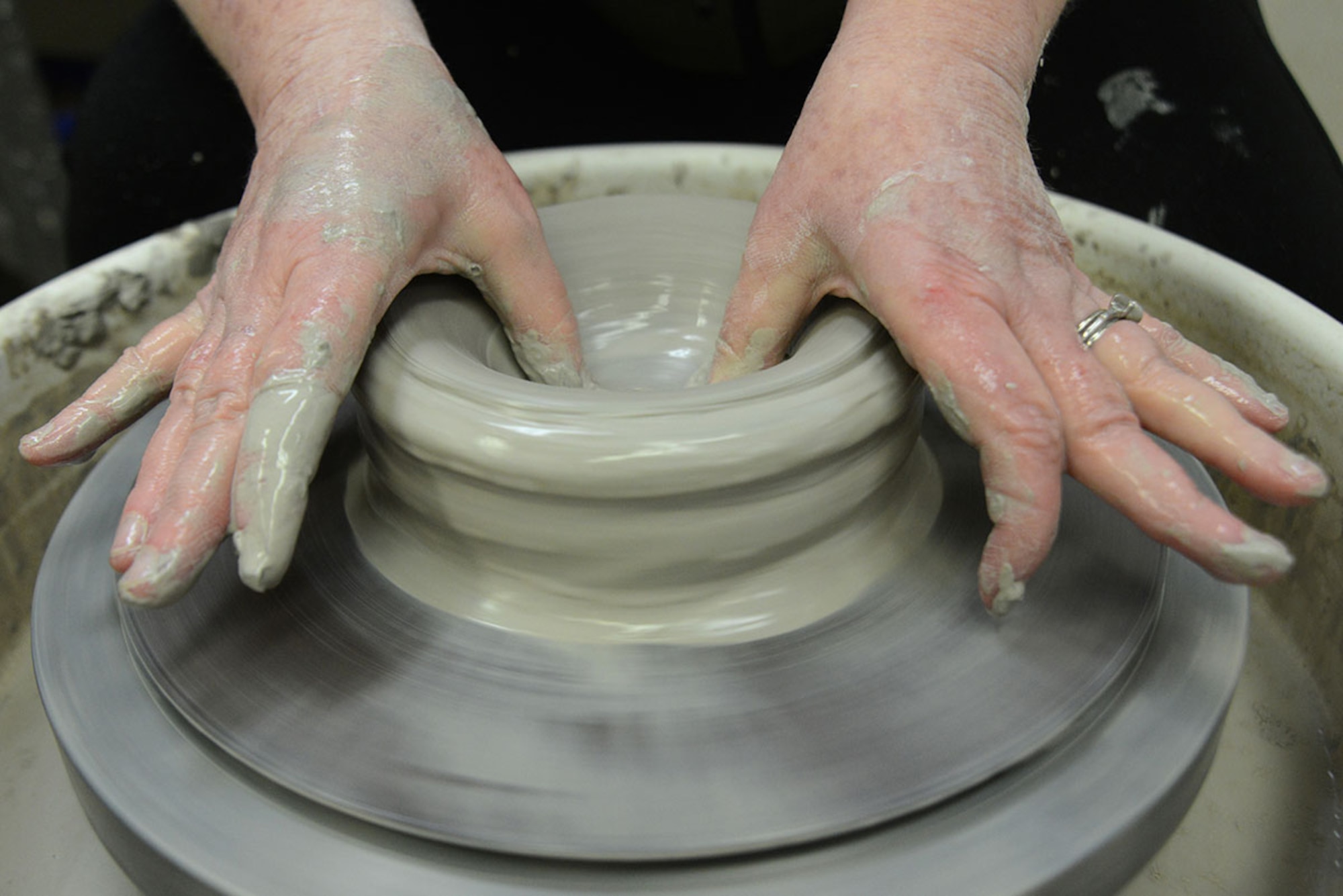 U.S. Coast Guard spouse Laura Fox spreads the inside of a clay bowl on a pottery wheel at the Polar Express Arts and Crafts Center at Joint Base Elmendorf-Richardson, Alaska, Feb. 28, 2016. Fox began creating pottery four years ago, but moved to Alaska seven months ago with her spouse Senior Chief Petty Officer Alan Fox, United States Coast Guard Sector Anchorage command center supervisor. (U.S. Air Force photo by Airman 1st Class Christopher R. Morales)
