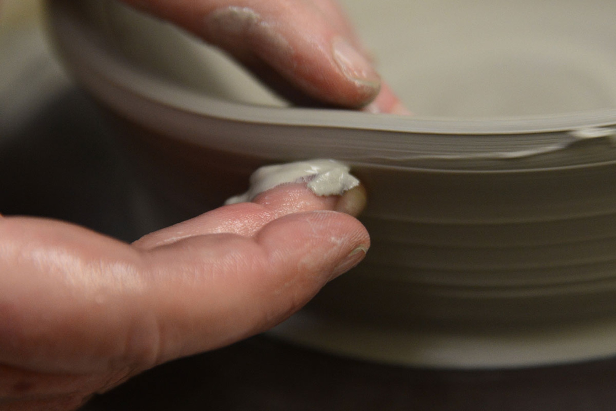 U.S. Coast Guard spouse Laura Fox molds a bowl with her fingers on a pottery wheel at the Polar Express Arts and Crafts Center at Joint Base Elmendorf-Richardson, Alaska, Feb. 28, 2016. Fox began creating pottery four years ago, but moved to Alaska seven months ago with her spouse Senior Chief Petty Officer Alan Fox, United States Coast Guard Sector Anchorage command center supervisor. Fox says pottery is like a baby; it starts out as clay, you mold it and take care of it, though it takes a long time to make; and whether it cracks in the kiln or gets dropped or broken – you love it anyway. (U.S. Air Force photo by Airman 1st Class Christopher R. Morales)