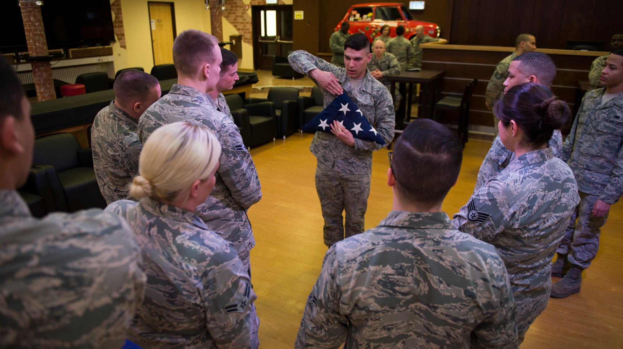 U.S. Air Force Senior Airman Tylor Pelletier, U.S. Air Force Honor Guard drill team member, shows the proper way to handle a U.S. Flag during honor guard training at Spangdahlem Air Base, Germany, March 16, 2016. The Base Honor Guard Training Program standardizes ceremonies and the manner in which they are performed from base to base, across the Air Force. (U.S. Air Force photo by Staff Sgt. Christopher Ruano/Released)
