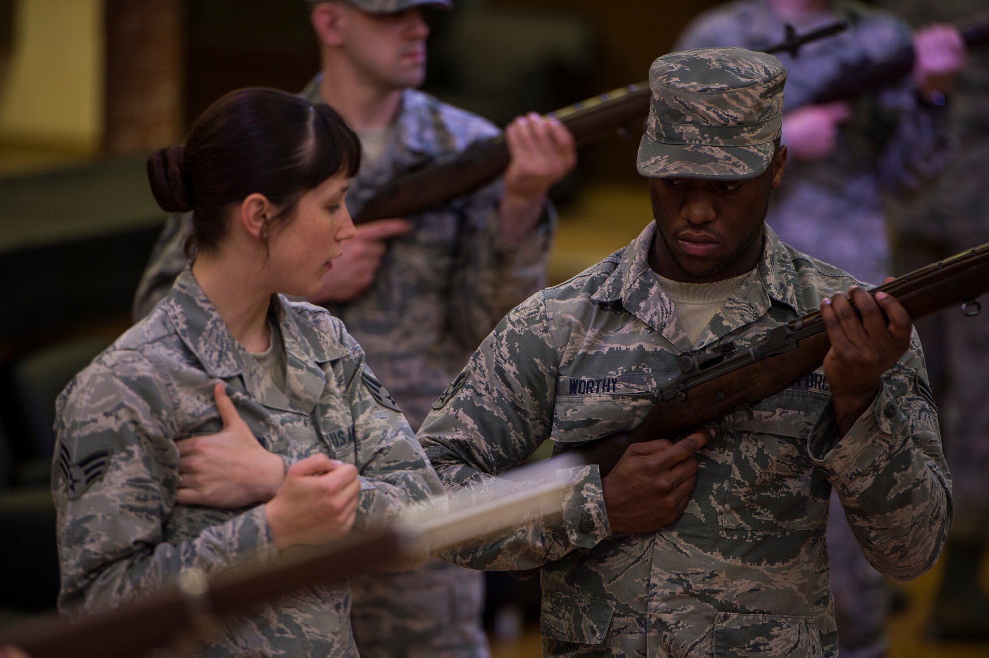 U.S. Air Force Senior Airman Amber Marcum, U.S. Air Force Honor Guard base honor guard program coordinator, shows proper rifle position to U.S. Air Force Airman 1st Class Jaylon Worthy, a 52nd Civil Engineer Squadron Heating, Ventilation and Air Conditioning technician, during honor guard training at Spangdahlem Air Base, Germany, March 16, 2016. The Base Honor Guard Training Program provides detailed instructions on key areas such as manuals, uniforms, history and traditions, and a variety of ceremonies. (U.S. Air Force photo by Staff Sgt. Christopher Ruano/Released)
