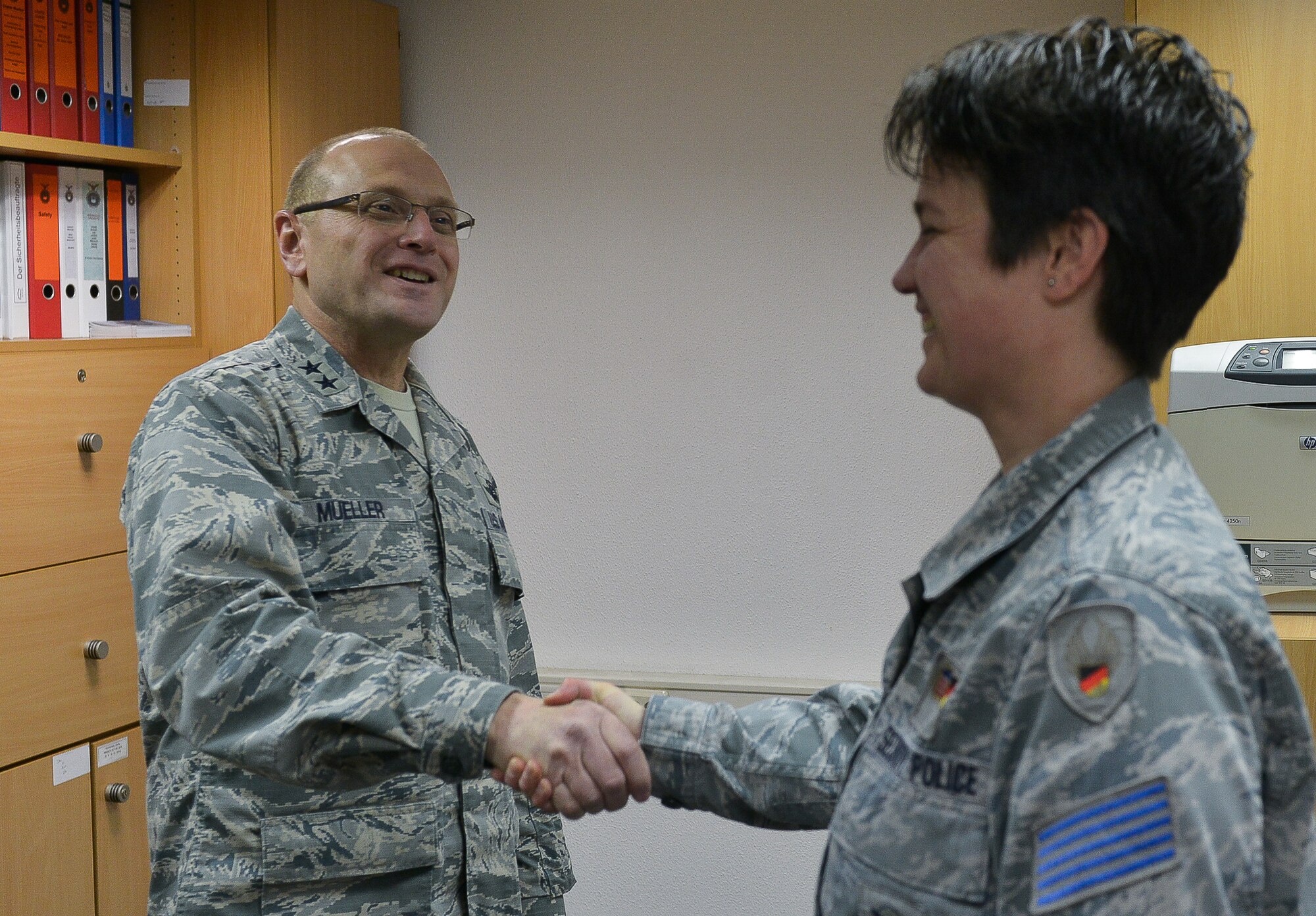 Maj. Gen. Andrew Mueller, Air Force chief of safety, congratulates ZB-5 Marina Mueller, 86th Security Forces Squadron administrative assistant, with a challenge-coin March 11, 2016, at Ramstein Air Base, Germany. Mueller was coined for being identified as one of the most productive safety representatives on the base. (U.S. Air force photo/Airman 1st Class Lane T. Plummer)